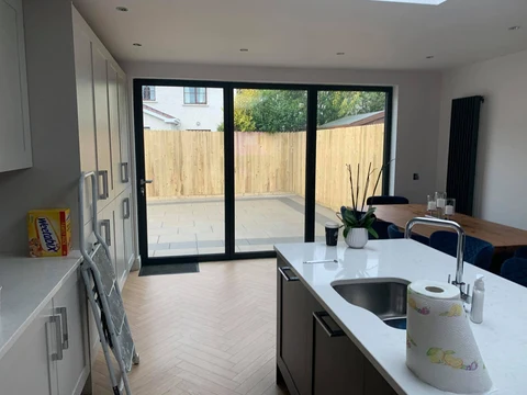 Bifold doors onto a lawn, anthracite frames