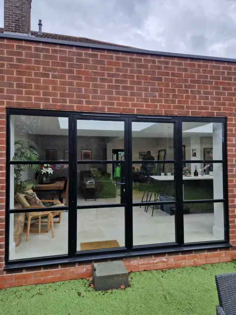 Heritage-bar aluminium screen in a brick elevation, looking into a living room